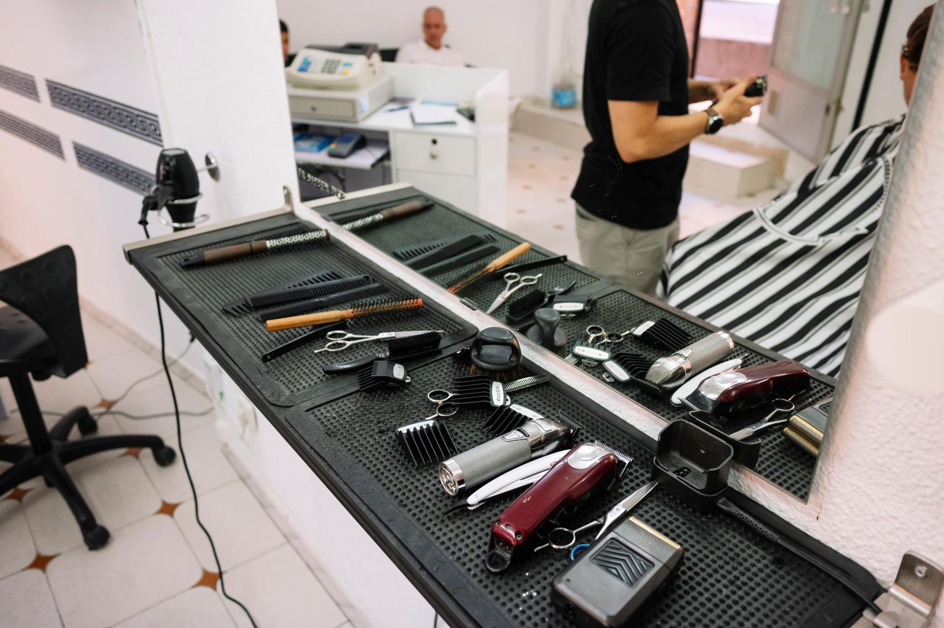 Barber tools arranged on workstation in barbershop.
